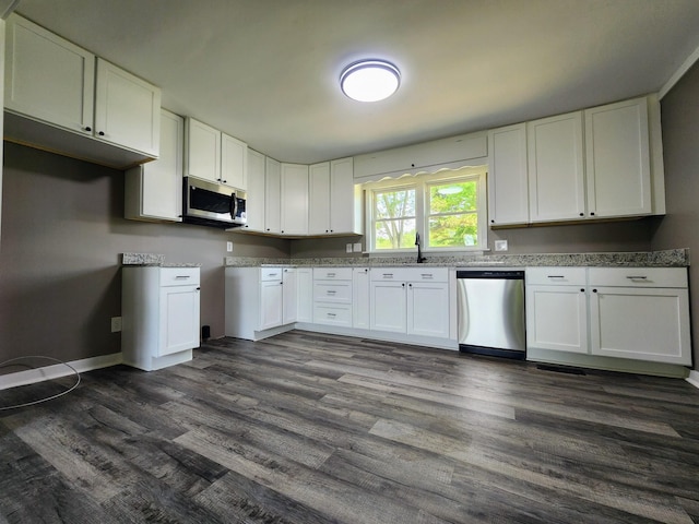 306 Johnson St, Lawrenceburg, TN 38464 - kitchen featuring appliances with stainless steel finishes, dark wood finished floors, white cabinetry, and baseboards