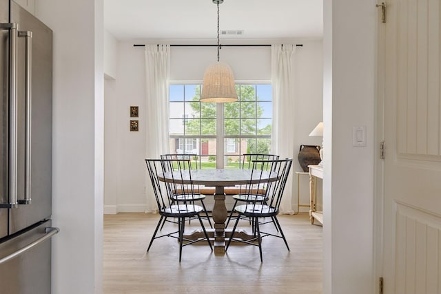 dining space featuring light wood-type flooring and baseboards