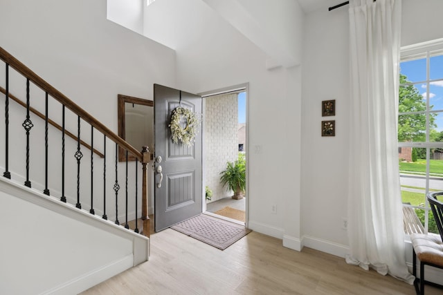 entrance foyer featuring wood finished floors, stairs, and baseboards