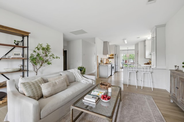 living area with light wood-type flooring and baseboards
