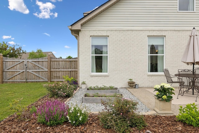 rear view of house featuring a patio and a gate