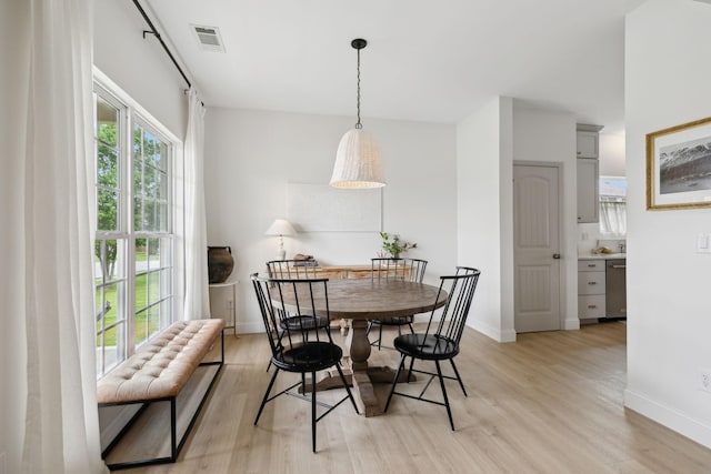 dining area featuring light wood-type flooring and baseboards