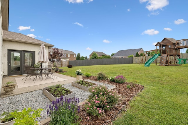 view of yard featuring a playground, a vegetable garden, and a patio area