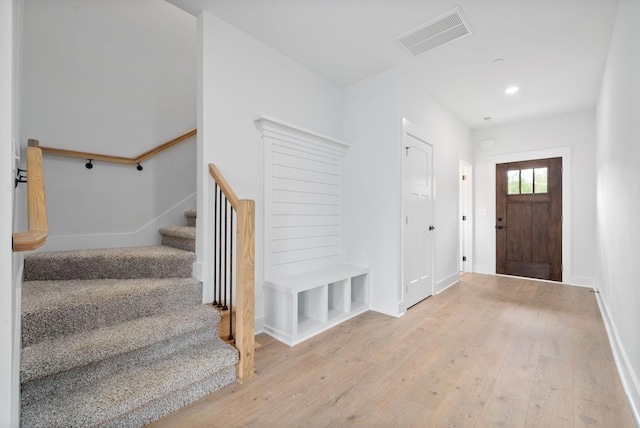 entryway featuring wood finished floors, stairway, baseboards, and recessed lighting