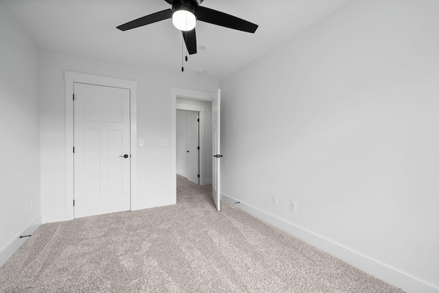 unfurnished bedroom featuring carpet floors, baseboards, and a ceiling fan