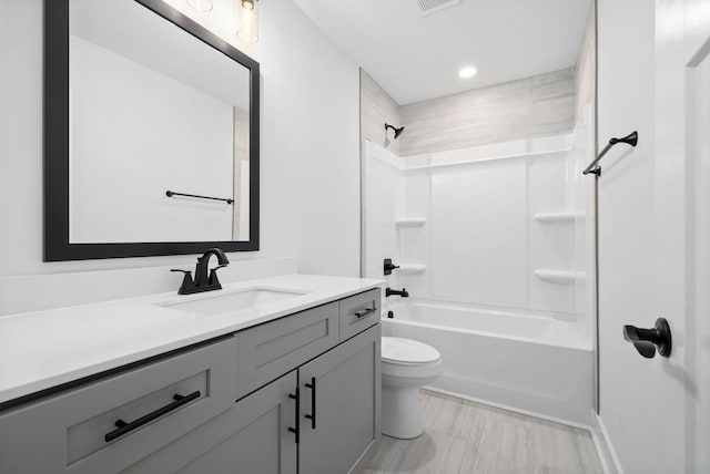 bathroom with toilet, vanity, and shower / tub combination
