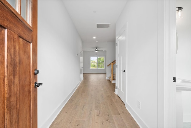hall with light wood-style flooring, recessed lighting, baseboards, and stairs