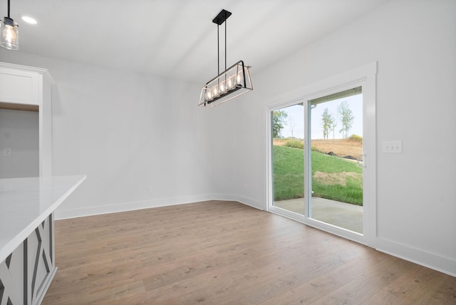 unfurnished dining area with light wood-type flooring, baseboards, and recessed lighting