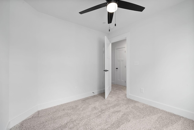 carpeted empty room featuring a ceiling fan and baseboards