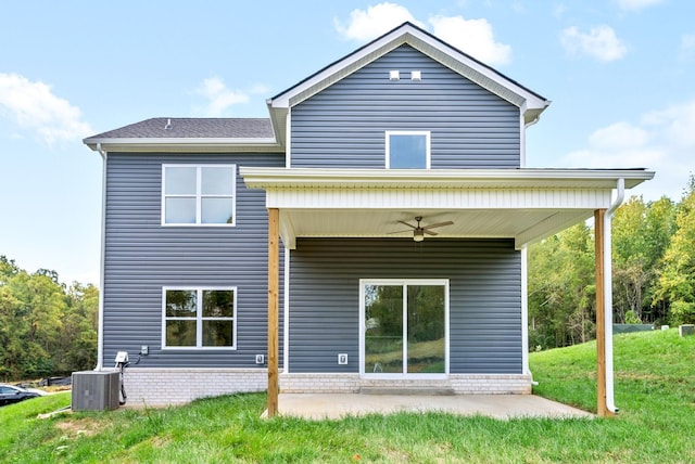 rear view of house with ceiling fan, central AC unit, a yard, and a patio