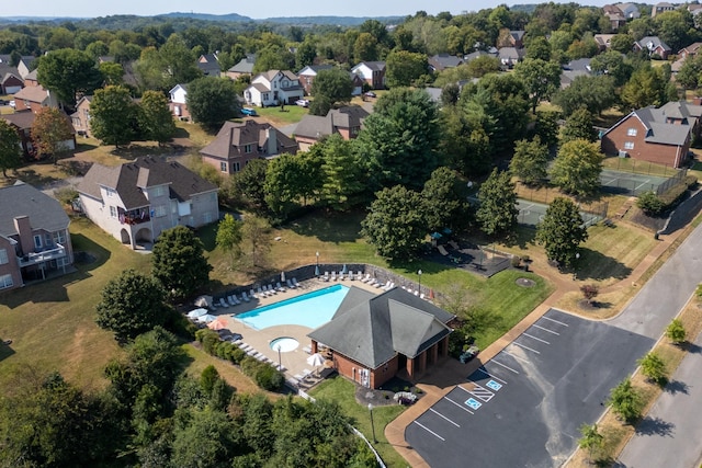 aerial view of property's location featuring a pool and nearby suburban area
