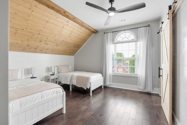 bedroom featuring a barn door, dark wood-type flooring, lofted ceiling, ceiling fan, and baseboards