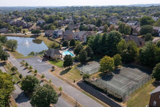 aerial view of property's location featuring nearby suburban area, a nearby body of water, and a pool