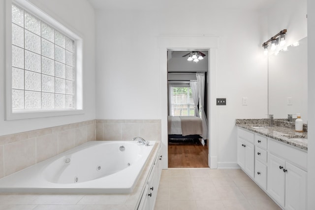 bathroom with connected bathroom, double vanity, a whirlpool tub, ceiling fan, and tile patterned floors