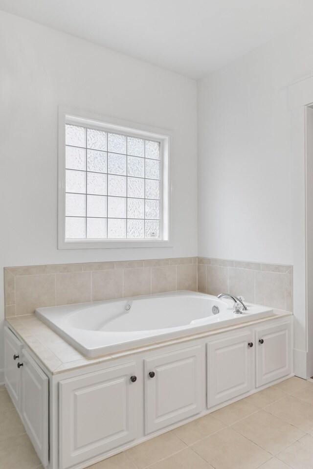 bathroom with a garden tub and tile patterned floors