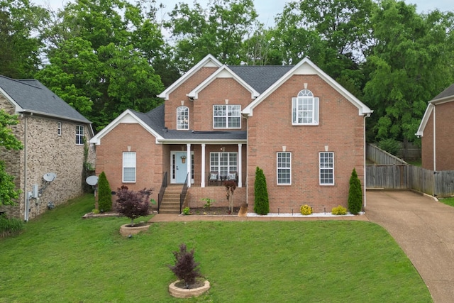 traditional home featuring brick siding, a porch, and concrete driveway