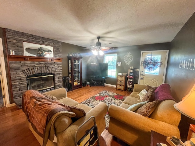 3517 Dobbins Pike, Portland, TN 37148 - living area featuring a textured ceiling, wood finished floors, ceiling fan, baseboards, and a fireplace