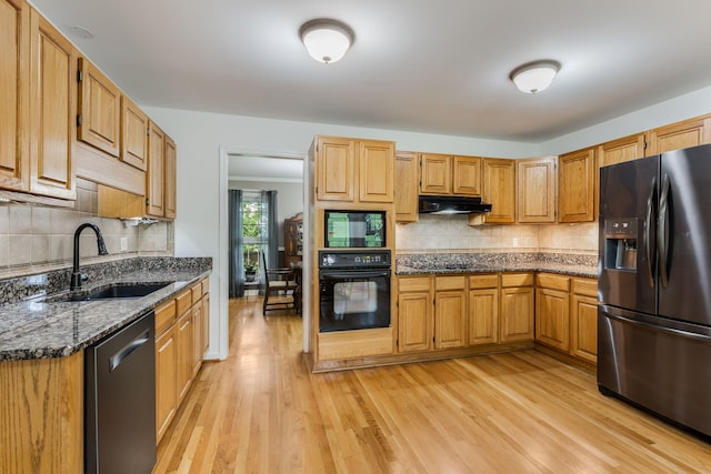 4060 Carters Creek Pike, Franklin, TN 37064 - kitchen featuring black appliances, under cabinet range hood, a sink, decorative backsplash, and light wood finished floors
