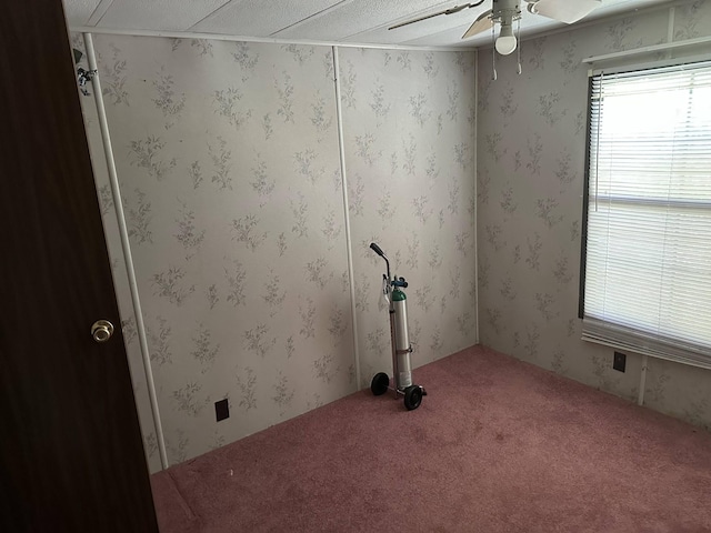 carpeted spare room with a ceiling fan