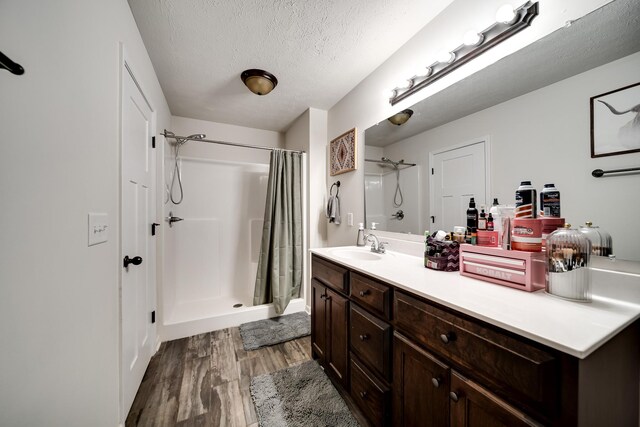 107 Tanesha Ct, Portland, TN 37148 - bathroom featuring wood finished floors, a stall shower, vanity, a textured ceiling, and baseboards