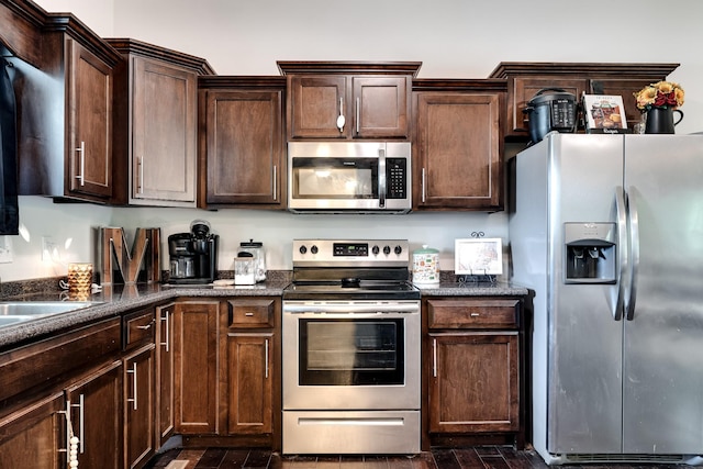 107 Tanesha Ct, Portland, TN 37148 - kitchen with stainless steel appliances, dark brown cabinetry, dark stone countertops, and dark wood finished floors