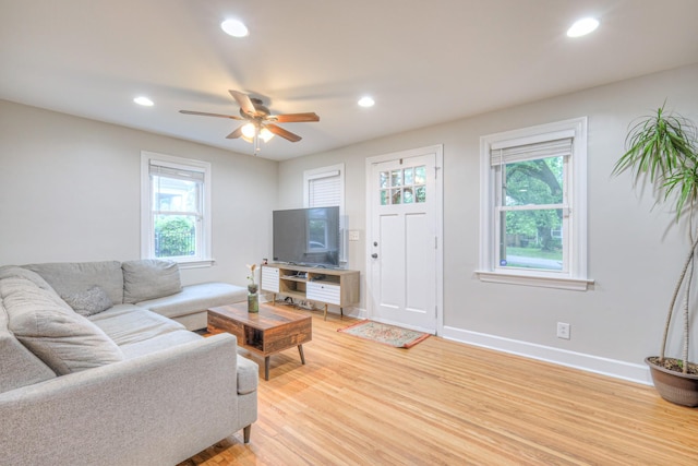 living area with healthy amount of natural light, light wood-style flooring, recessed lighting, a ceiling fan, and baseboards