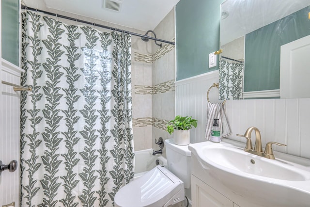 full bath featuring wainscoting, toilet, shower / tub combo with curtain, and vanity