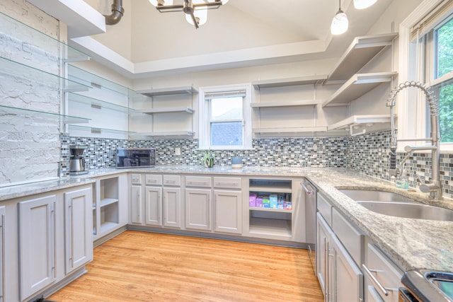 kitchen with open shelves, a sink, stove, backsplash, and lofted ceiling