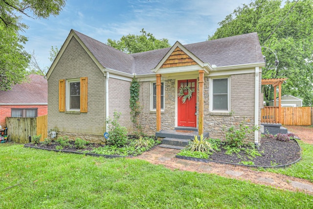 view of front of home with a shingled roof, brick siding, and stone siding