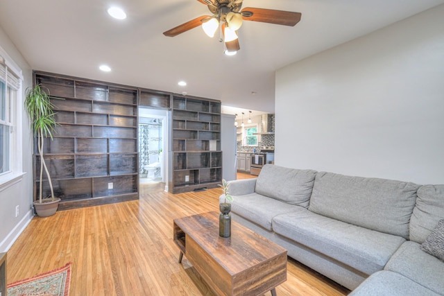 living area featuring a ceiling fan, light wood-type flooring, recessed lighting, and baseboards