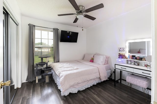 bedroom featuring dark wood finished floors, a ceiling fan, and a closet