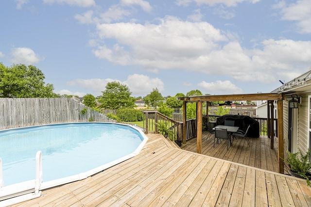 view of pool featuring a wooden deck, a fenced backyard, and outdoor dining area