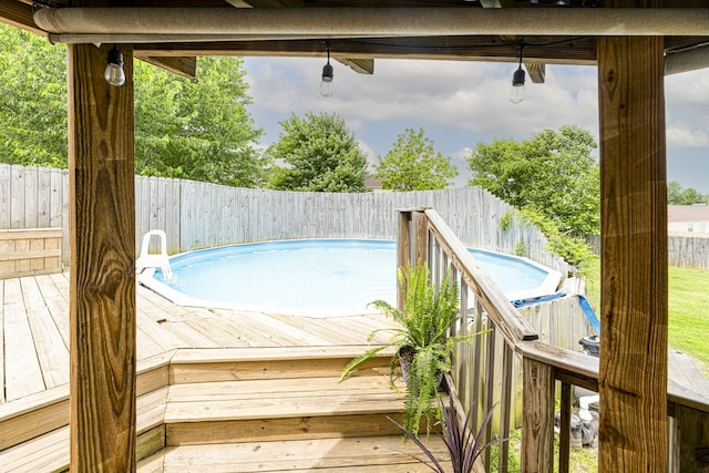 view of swimming pool featuring a fenced backyard and a deck