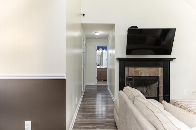 corridor with dark wood-type flooring and baseboards