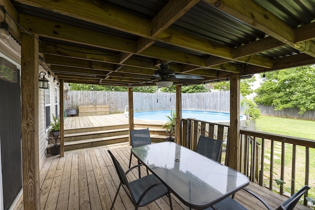 wooden terrace with outdoor dining area and ceiling fan