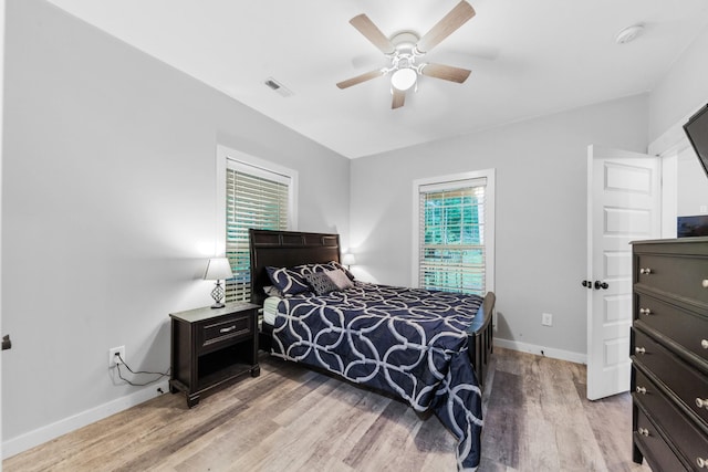 bedroom featuring baseboards, light wood finished floors, and a ceiling fan
