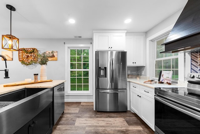 kitchen featuring appliances with stainless steel finishes, custom range hood, white cabinetry, dark wood-style flooring, and pendant lighting