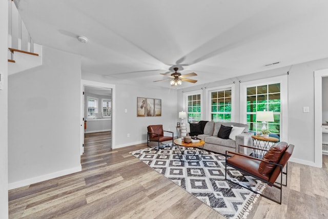 living room with a ceiling fan, wood finished floors, and baseboards