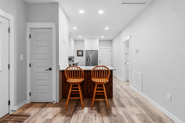 dining space featuring light wood-type flooring, recessed lighting, and baseboards