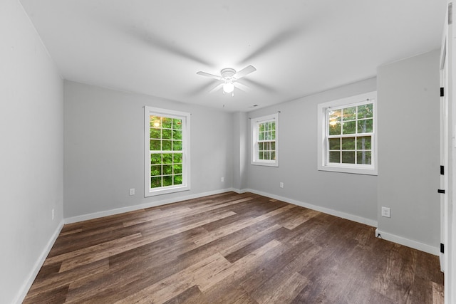 spare room featuring dark wood finished floors, baseboards, and ceiling fan