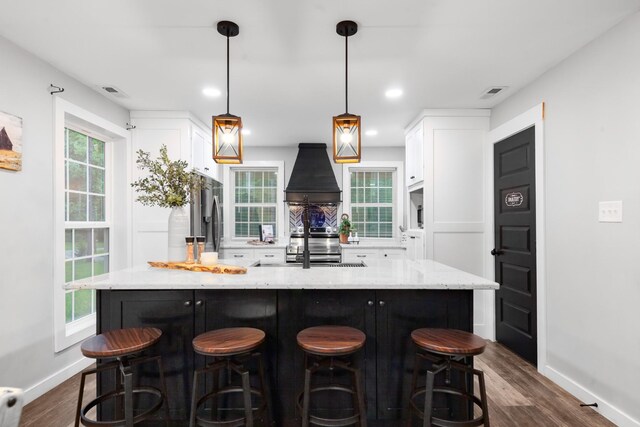 kitchen featuring custom exhaust hood, baseboards, white cabinetry, and stainless steel refrigerator with ice dispenser