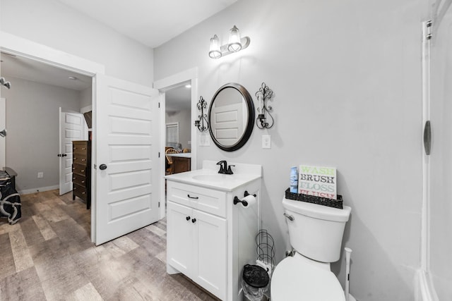 bathroom featuring wood finished floors, vanity, and toilet