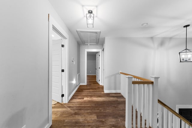 hall with attic access, an upstairs landing, wood finished floors, and baseboards