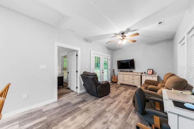 living room featuring attic access, wood finished floors, a ceiling fan, and french doors