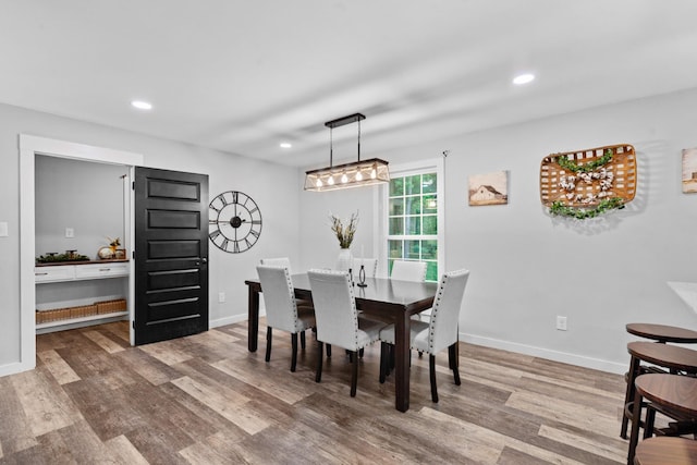 dining room featuring wood finished floors, recessed lighting, and baseboards