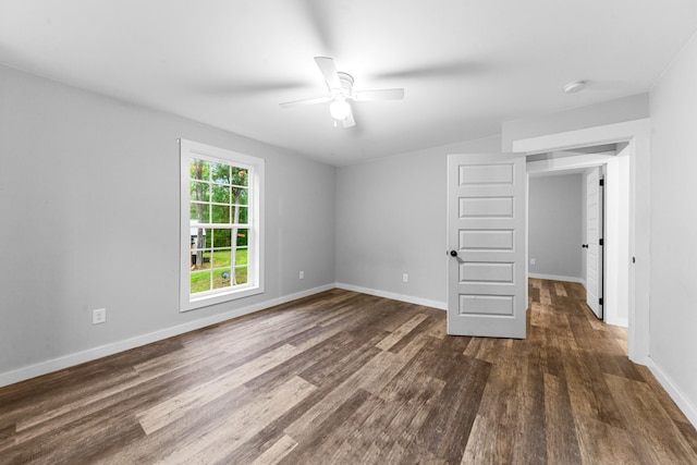 unfurnished room featuring wood finished floors, a ceiling fan, baseboards, and a smoke detector