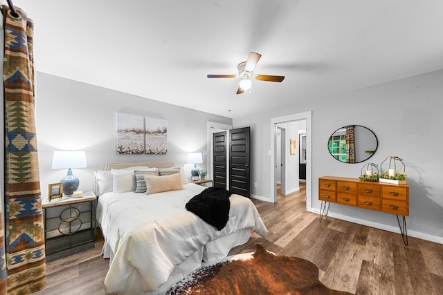 bedroom featuring baseboards, wood finished floors, and ceiling fan
