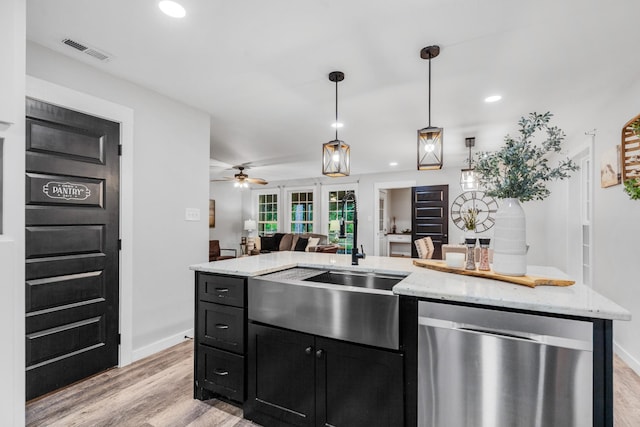 kitchen featuring stainless steel dishwasher, dark cabinetry, light wood finished floors, open floor plan, and ceiling fan