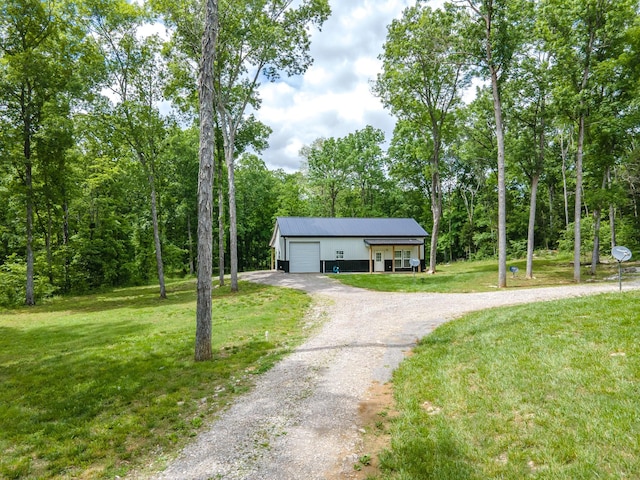 view of front facade featuring a front lawn, dirt driveway, and a garage