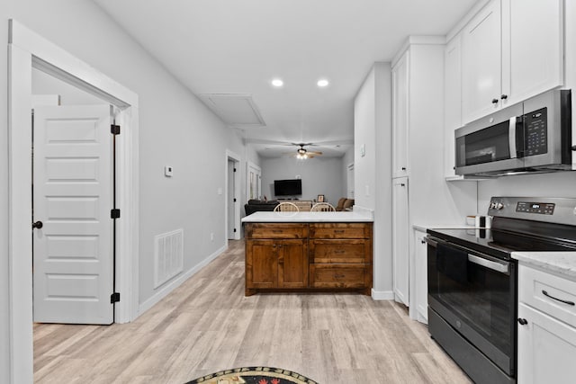 kitchen featuring appliances with stainless steel finishes, light wood-type flooring, white cabinetry, recessed lighting, and baseboards